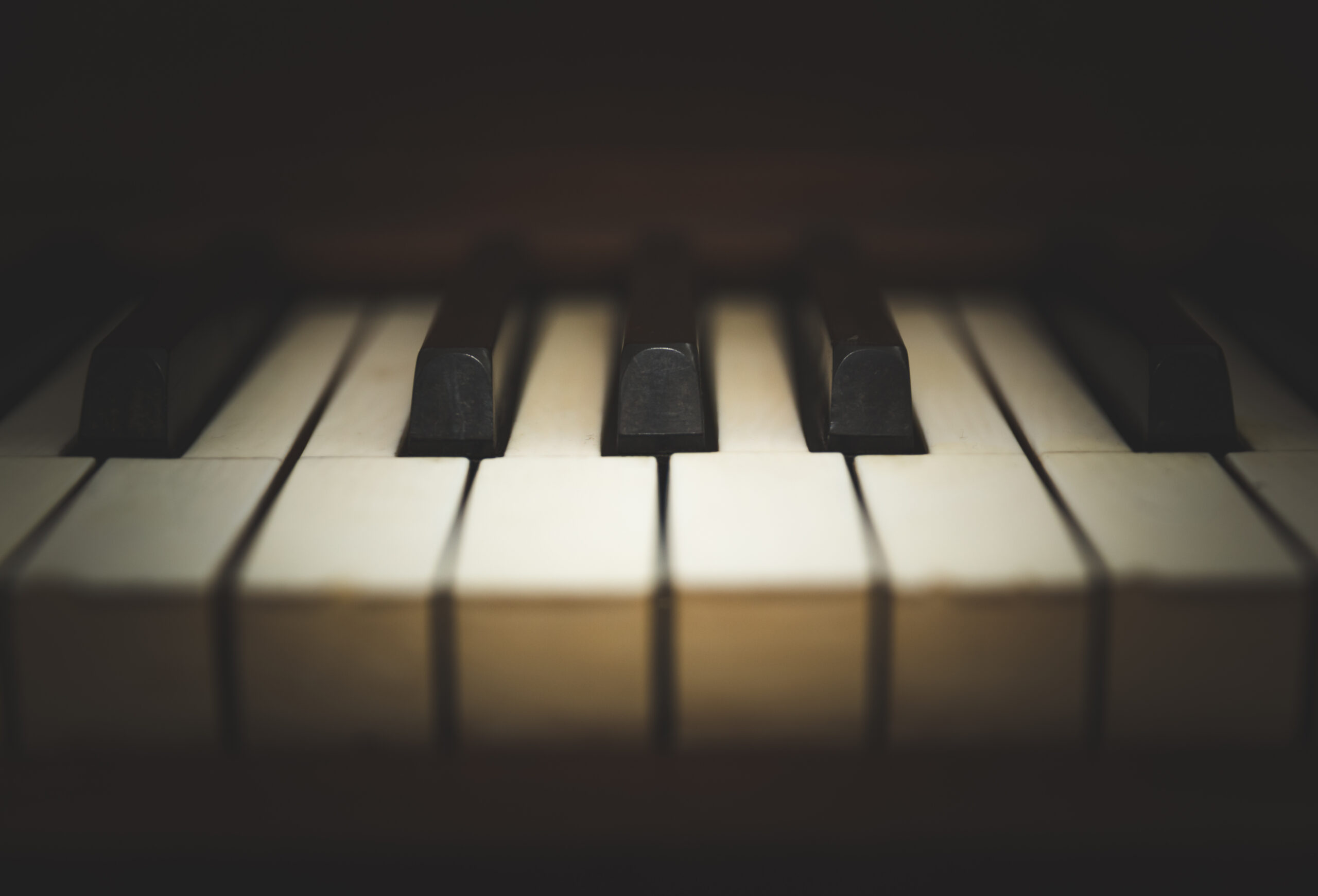 Close-up view of keys on an antique, wooden, upright piano.