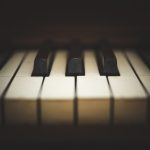 Close-up view of keys on an antique, wooden, upright piano.